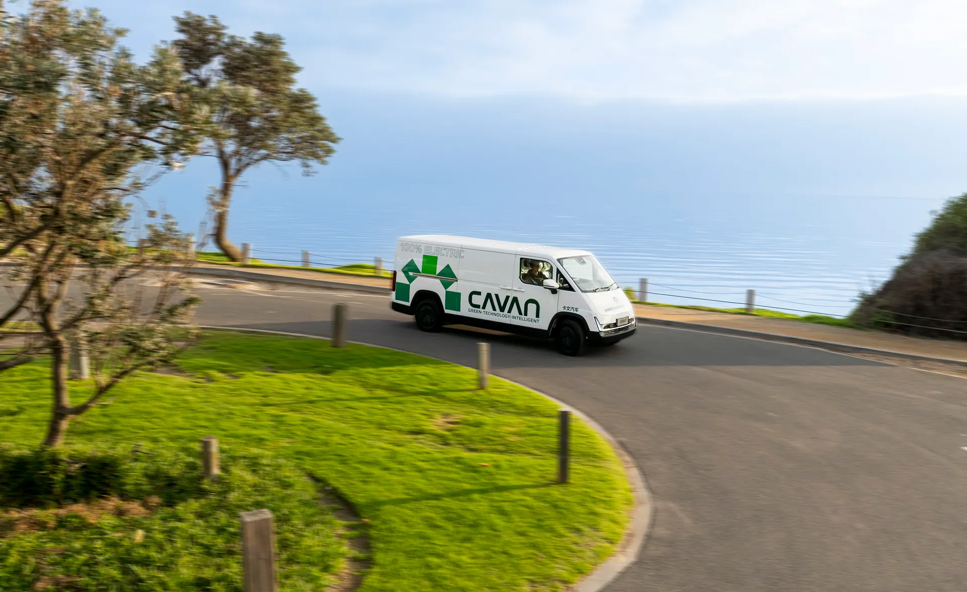 Aerial view of a Cavan electric van rounding a clifftop coastal bend